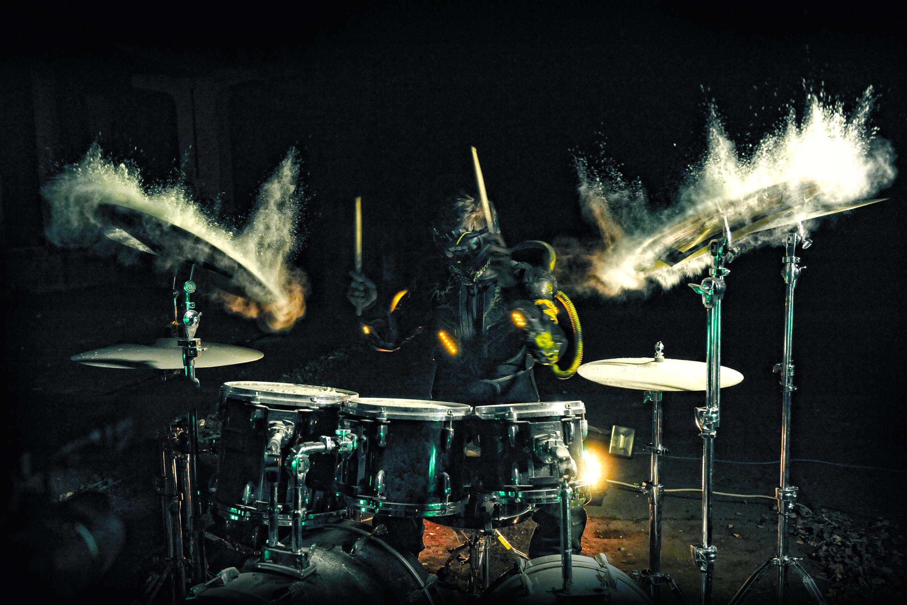 Drummer playing a dusty drumkit, to create a dramatic effect